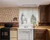 Kitchen with sink, ornamental molding, dark brown cabinets, and black range with gas cooktop