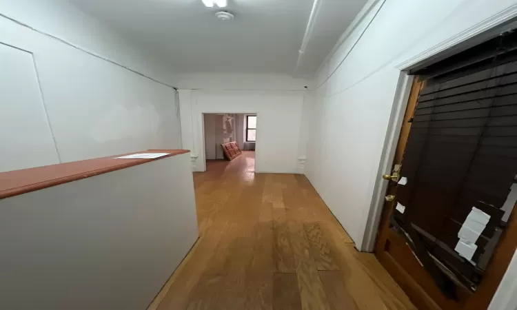 Corridor with hardwood / wood-style floors