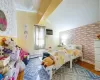 Bedroom with a wall mounted air conditioner, vaulted ceiling, a baseboard radiator, and hardwood / wood-style flooring