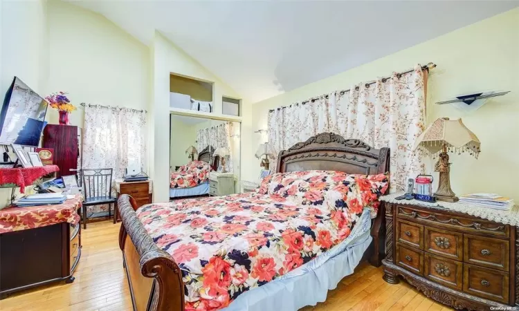 Bedroom with vaulted ceiling and light hardwood / wood-style floors