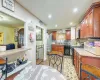 Kitchen featuring backsplash, light wood-type flooring, black appliances, and light stone counters