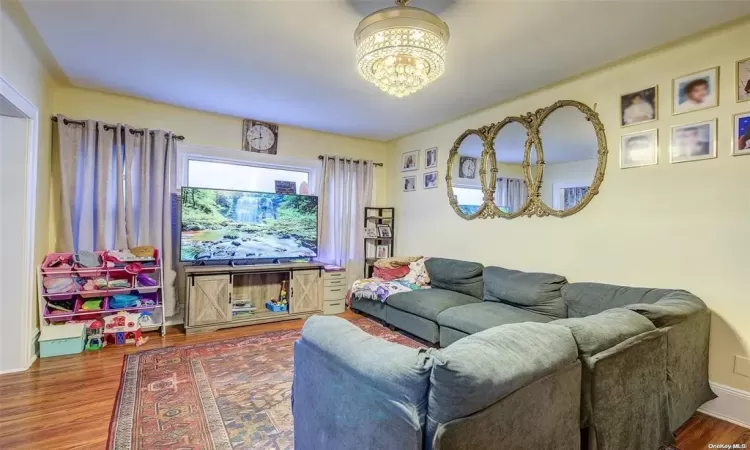 Living room featuring an inviting chandelier and wood-type flooring