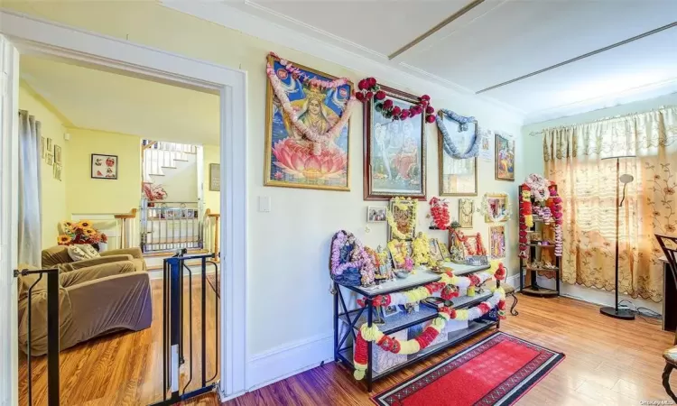 Rec room with hardwood / wood-style floors and ornamental molding