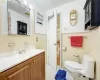 Bathroom featuring tile walls, tile patterned flooring, vanity, and toilet