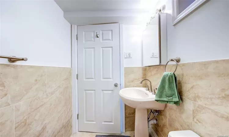 Bathroom with tile walls and toilet