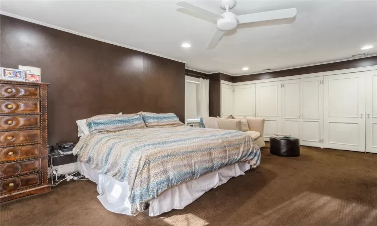 Carpeted bedroom featuring ceiling fan, crown molding, and a closet