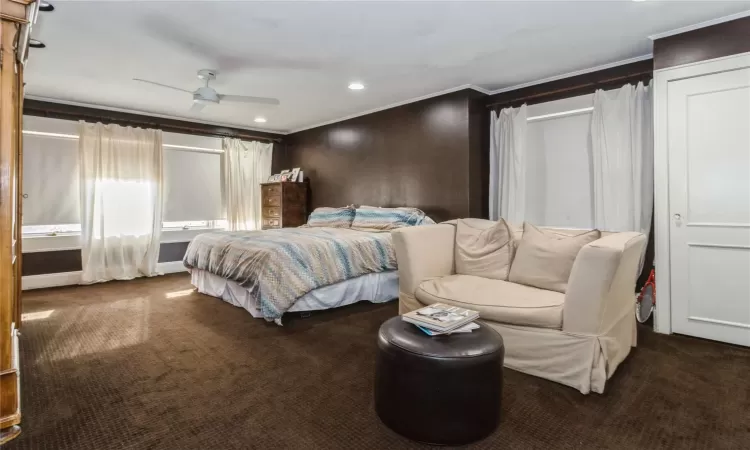 Carpeted bedroom with ornamental molding and ceiling fan