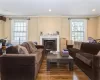 Living room featuring a wealth of natural light, crown molding, and a high end fireplace