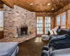 Living room featuring wood walls, french doors, carpet flooring, a fireplace, and wooden ceiling