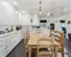 Kitchen with white appliances, white cabinetry, decorative light fixtures, and dark tile patterned floors