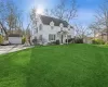 View of front of house featuring an outbuilding, a front lawn, and a garage