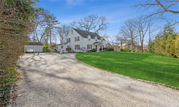 View of home's exterior with a garage, an outbuilding, and a lawn