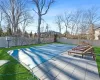 View of swimming pool featuring a yard, a patio area, and basketball hoop