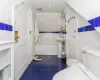 Bathroom featuring toilet, tile patterned flooring, tile walls, and tiled tub