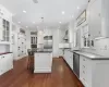 Kitchen with pendant lighting, a center island, high quality appliances, and white cabinetry