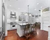 Kitchen featuring white cabinetry, a center island, premium range, pendant lighting