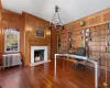 Office area with hardwood floors, fireplace, wood paneled walls, built in shelves