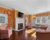 Ensuite Primary Bedroom room with crown molding, with fireplace, and hardwood floors and access to private sunroom