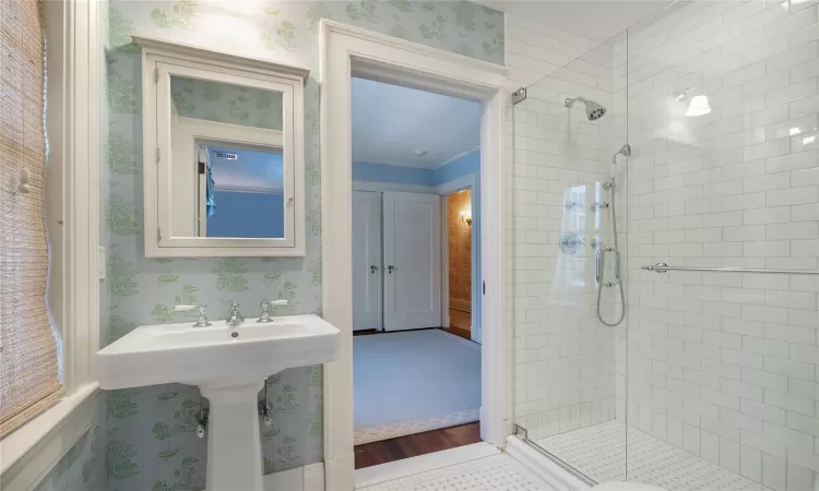 Bathroom featuring walk in shower and ornamental molding