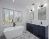 Bathroom featuring vanity, a tub, and crown molding