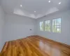 Empty room with a raised ceiling and light hardwood / wood-style flooring