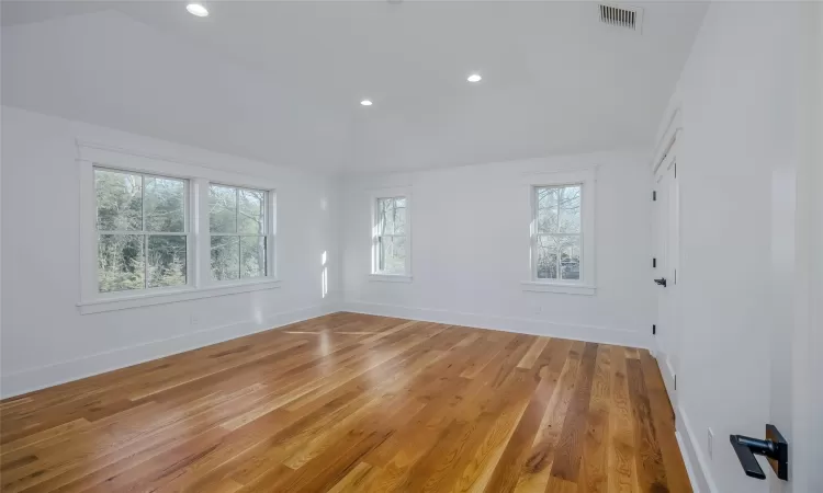 Unfurnished room featuring light hardwood / wood-style flooring and lofted ceiling