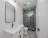 Bathroom featuring toilet, walk in shower, and vanity