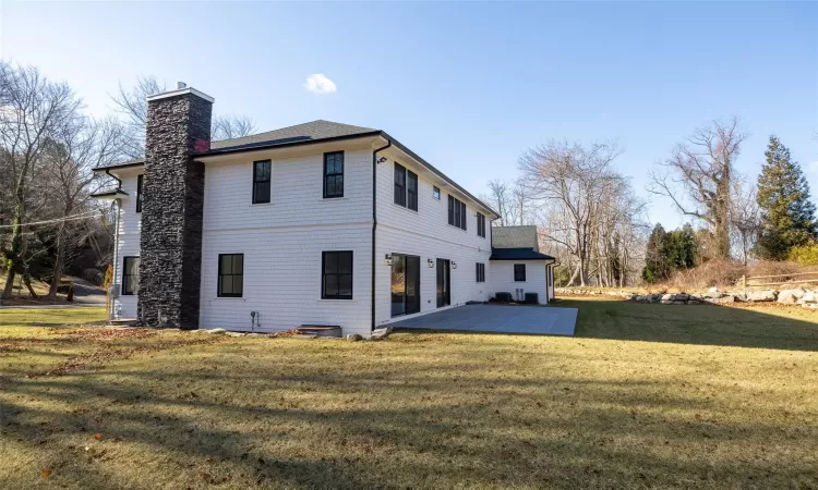 Back of property featuring a yard and a patio