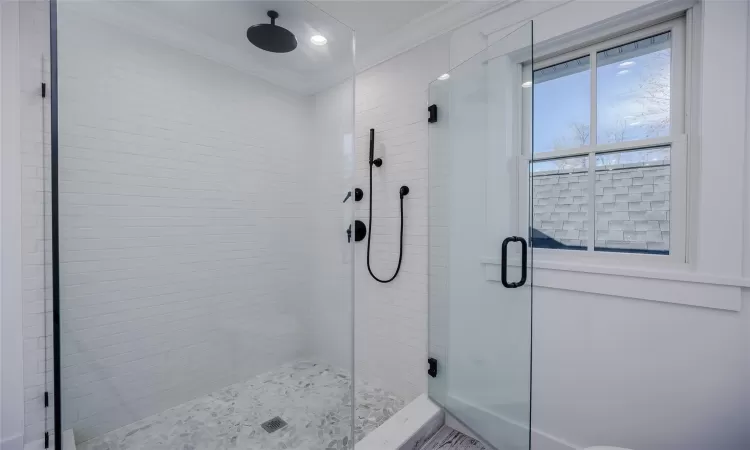 Bathroom featuring an enclosed shower and crown molding