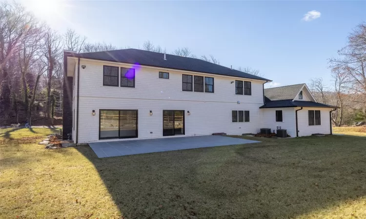 Rear view of house featuring central AC, a yard, and a patio