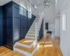 Stairway with an inviting chandelier, crown molding, a fireplace, and hardwood / wood-style floors