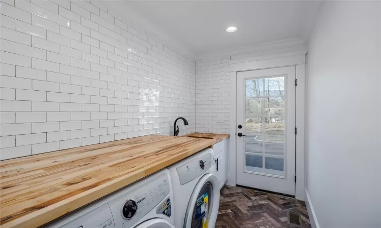 Washroom with ornamental molding, washing machine and clothes dryer, and sink