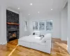 Living room with light wood-type flooring, a fireplace, and ornamental molding