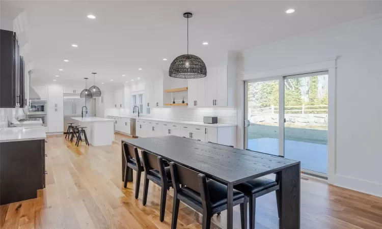 Dining room featuring sink, crown molding, and light hardwood / wood-style flooring