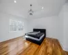 Bedroom featuring lofted ceiling, wood-type flooring, and an inviting chandelier