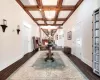 Hall with a notable chandelier, dark hardwood / wood-style floors, coffered ceiling, and beamed ceiling