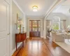 Foyer with ornate columns, lofted ceiling, crown molding, and parquet floors