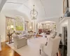 Living room featuring vaulted ceiling, a chandelier, a healthy amount of sunlight, and hardwood / wood-style floors