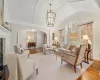 Living room with vaulted ceiling, an inviting chandelier, and light hardwood / wood-style flooring