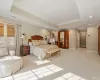 Carpeted bedroom featuring a raised ceiling and ornamental molding