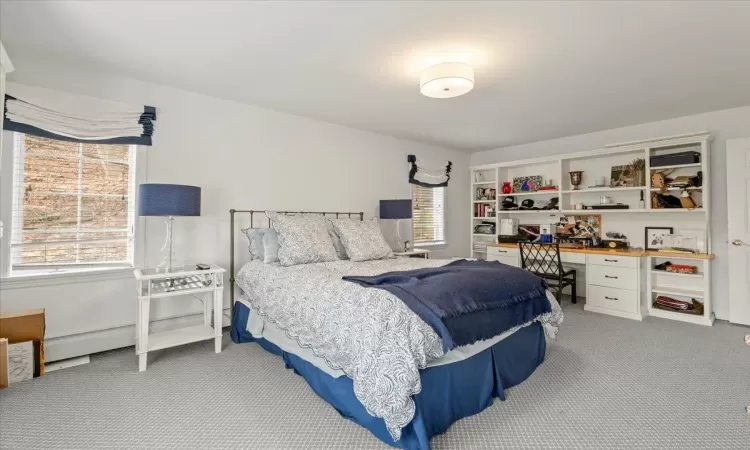 Bedroom featuring built in desk and carpet