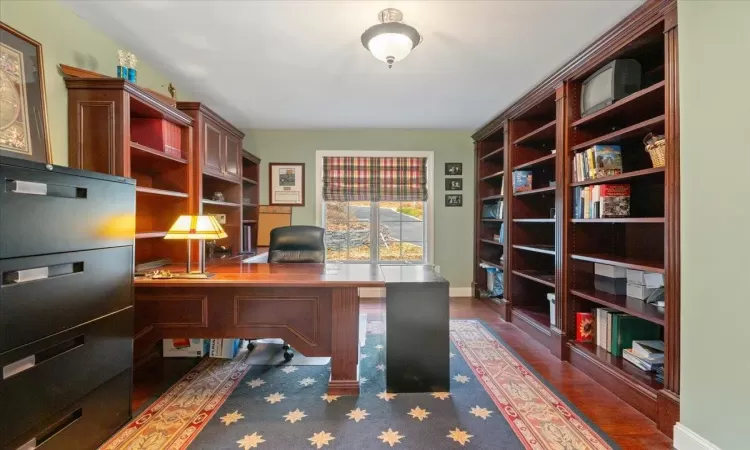 Office with dark hardwood / wood-style flooring