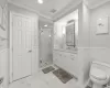 Bathroom with toilet, crown molding, a shower with shower door, and vanity