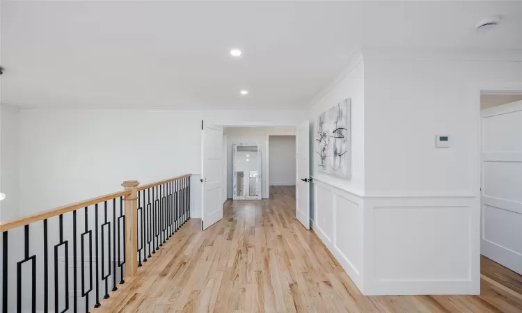 Hall featuring crown molding and light hardwood / wood-style flooring