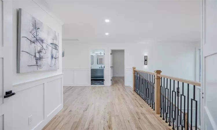 Corridor featuring ornamental molding and light hardwood / wood-style flooring