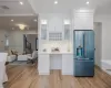 Kitchen featuring crown molding, high end refrigerator, light hardwood / wood-style floors, and white cabinets