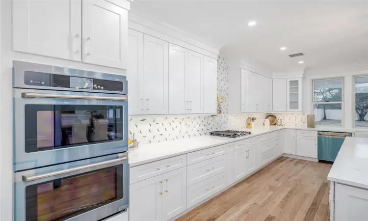 Kitchen featuring white cabinetry, appliances with stainless steel finishes, and light stone countertops