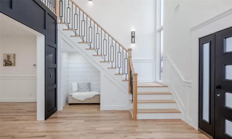 Stairs featuring hardwood / wood-style flooring and ornamental molding