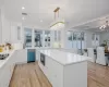 Kitchen featuring white cabinetry, a center island, dishwasher, and tasteful backsplash