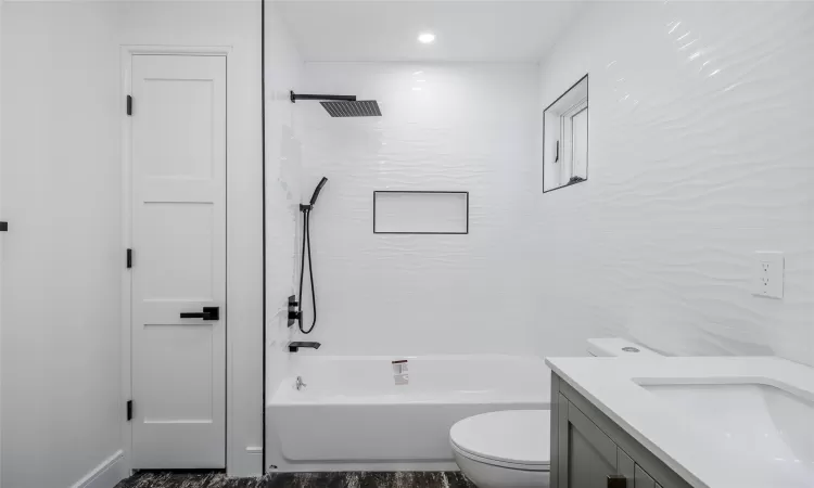 Full bathroom featuring vanity, toilet, and tiled shower / bath combo